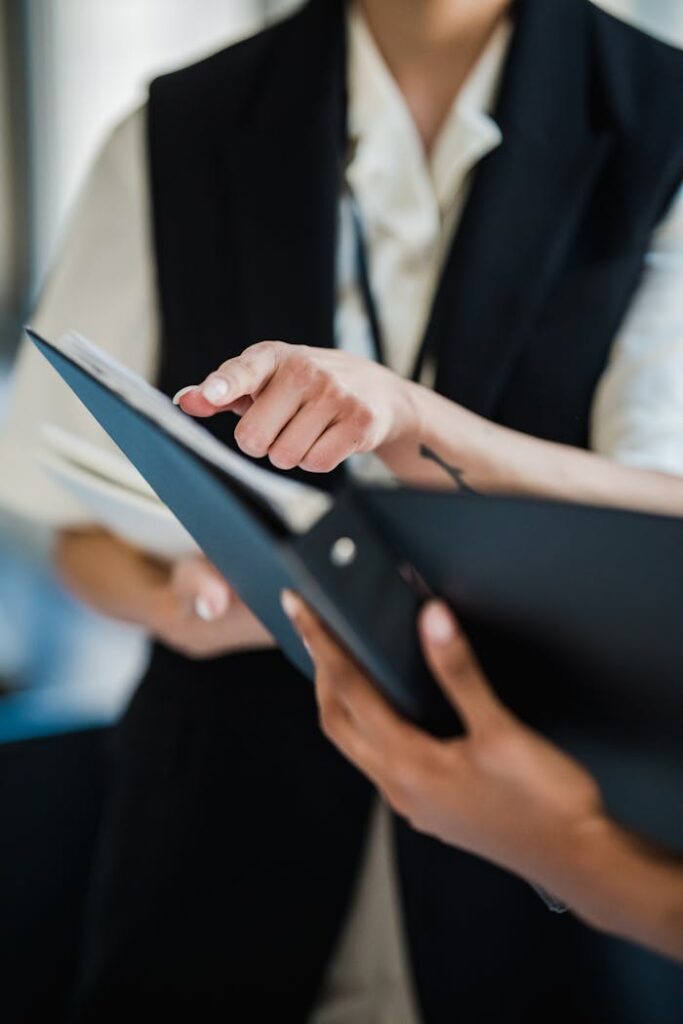 Two professionals pointing at documents during a collaborative office meeting.
