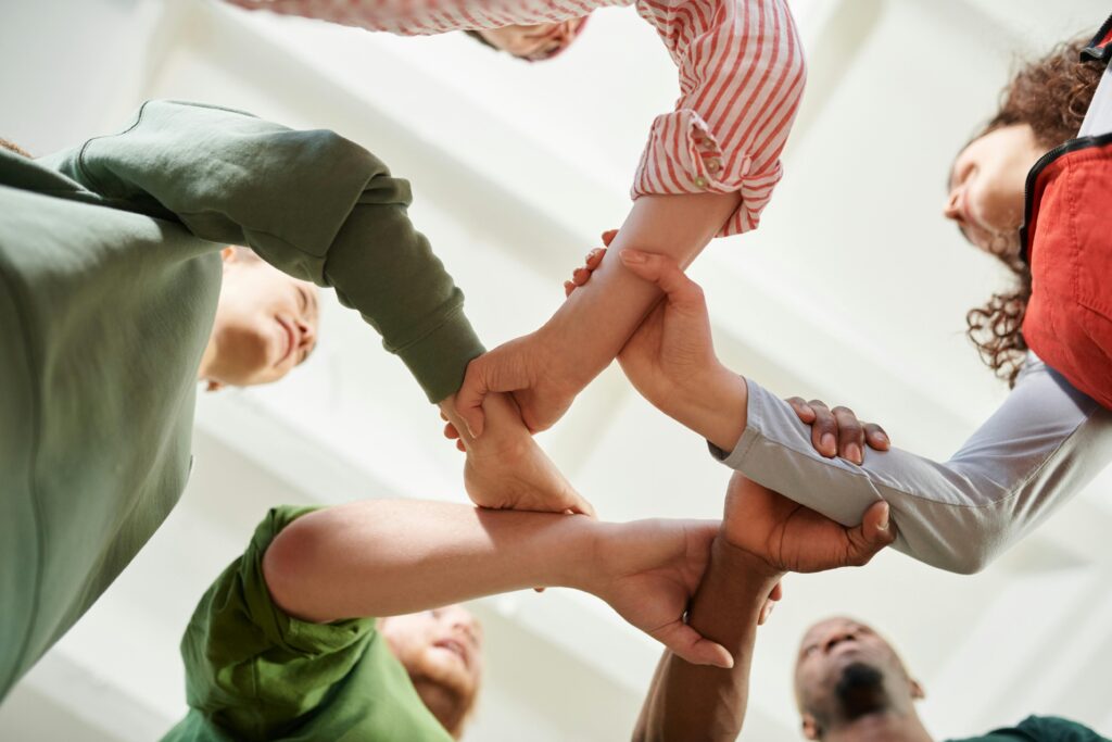 pexels photo 6995379 6995379 A diverse group of people join hands forming a unity circle, symbolizing teamwork and cooperation.